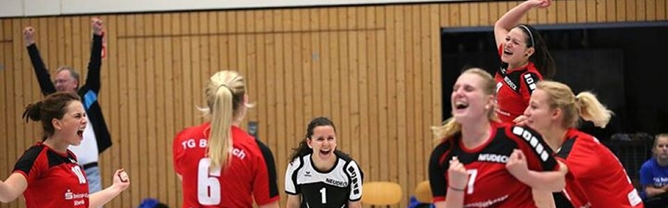 Teil einer jubelnden Frauenfußballmannschaft in einer Sporthalle