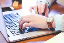 Ein Volontär für Online- und Printmedien sitzt am Laptop und schreibt einen Artikel