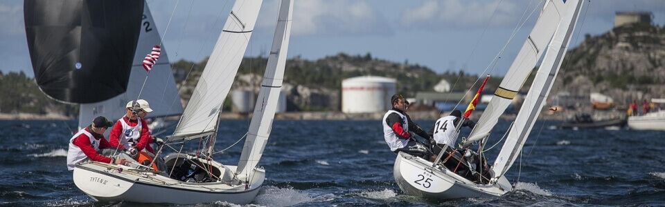 Zwei Segelboote mit entsprechender Besatzung segeln auf dem Wasser