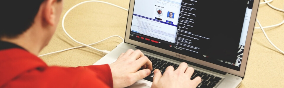 Eine Nahaufnahme von einem SEO Manager der am Laptop arbeitet