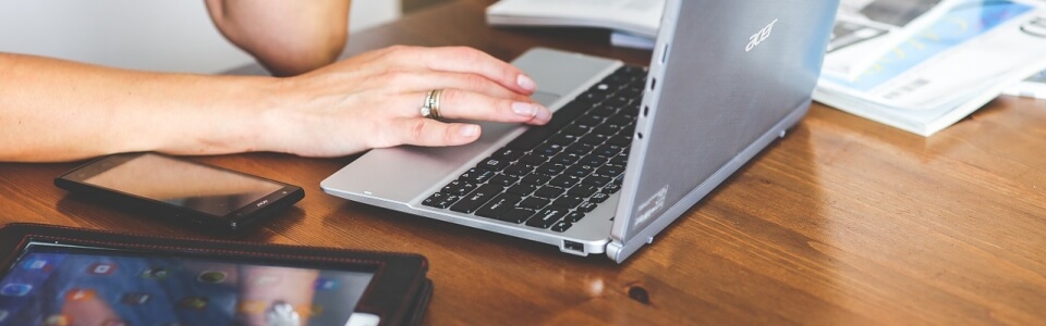 Nahaufnahme einer Marketing Redakteurin im Bereich Sport die am Laptop etwas schreibt