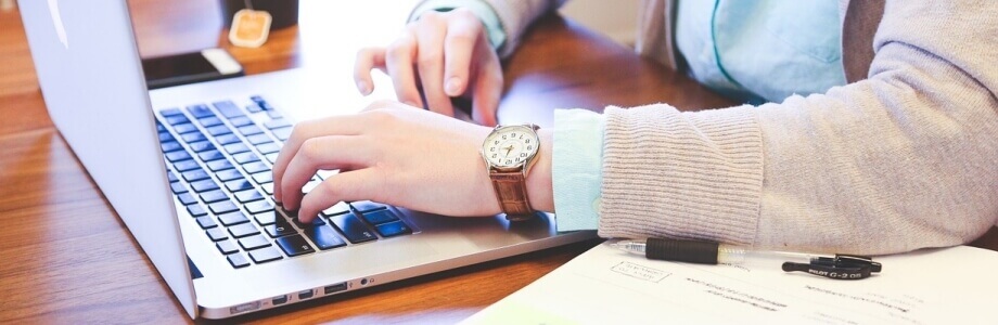 Nahaufnahme einer Volontaerin im Bereich Online und Print die am Laptop schreibt