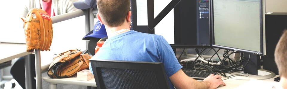 Sportberufe Online Marketing Ein Redakteur im Bereich Sportmarketing bearbeitet ein Bild am Computer