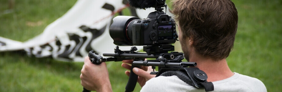 Volontaer im Bereich Sport TV filmt ein Fußballspiel mit Kamera