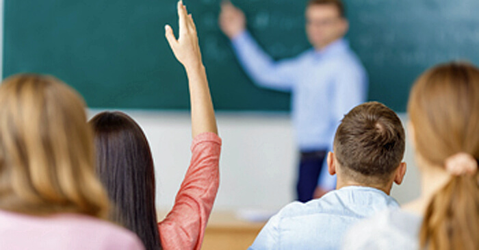 Berufsbegleitende Studentin meldet sich in einem Seminar