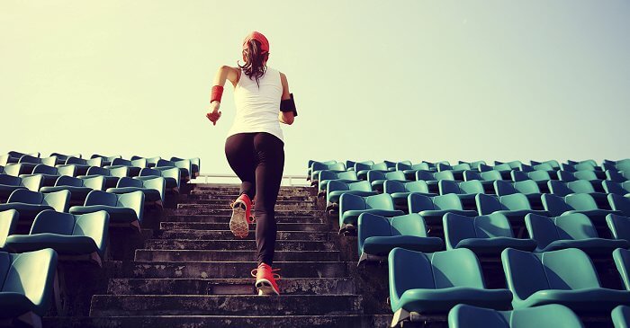 Frau läuft eine Stadiontreppe hoch