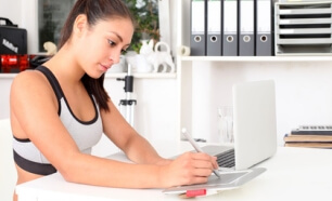 Duale Sportstudentin schreibt etwas an einem Tablet