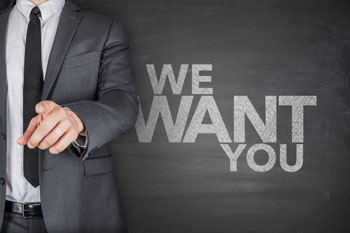 Mann im Anzug steht vor einer Tafel mit der Aufschrift 