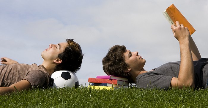 Zwei Sportstudenten entspannen gemeinsam auf einer Wiese