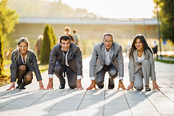 Vier Geschäftsleute auf einer Laufbahn.